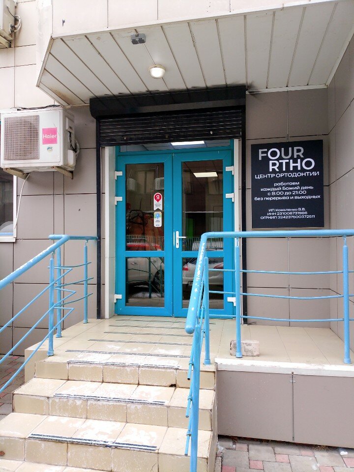 Вход в клинику Four Ortho с вывеской