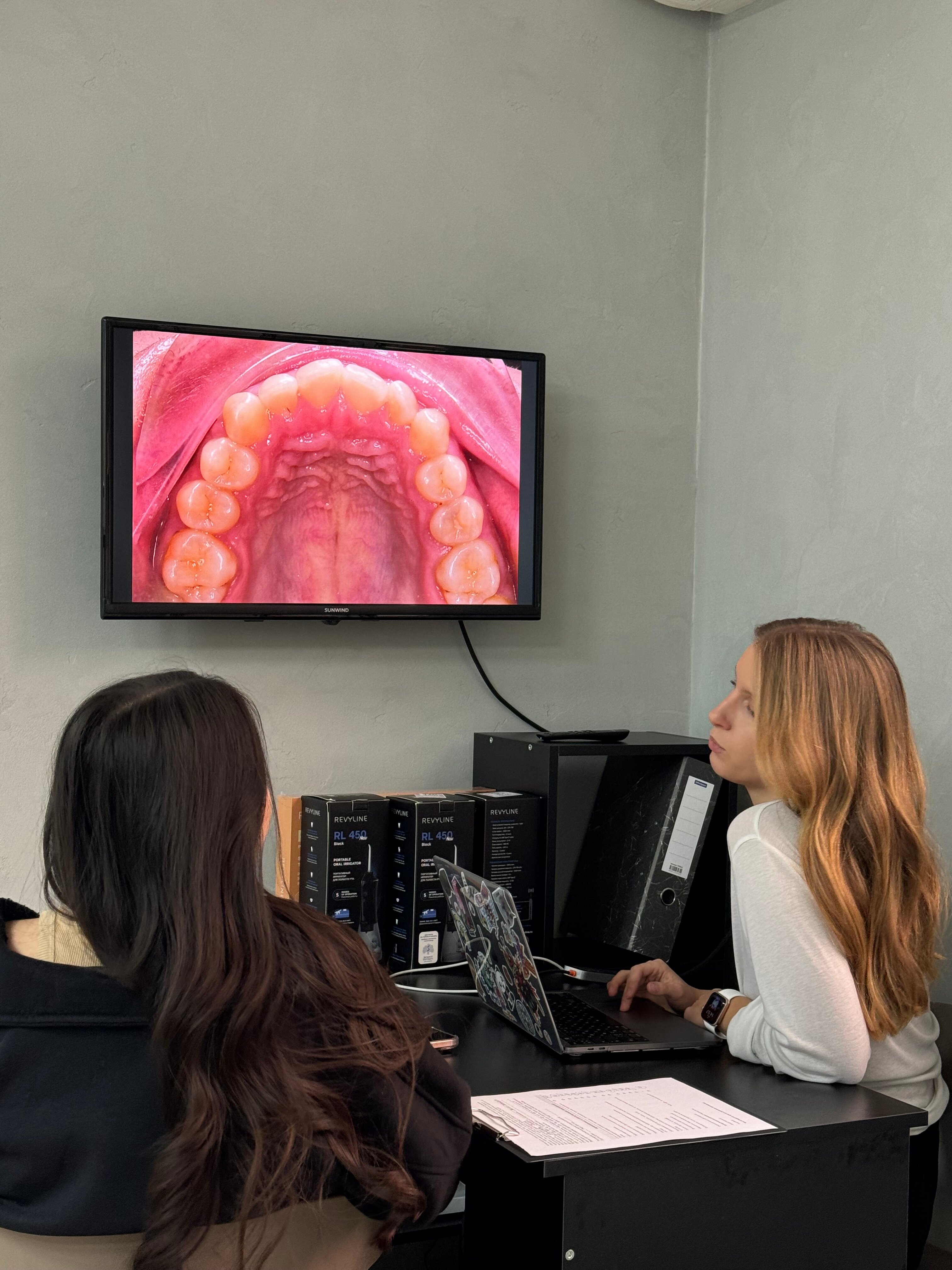 Врач Four Ortho обсуждает с пациентом состояние зубов